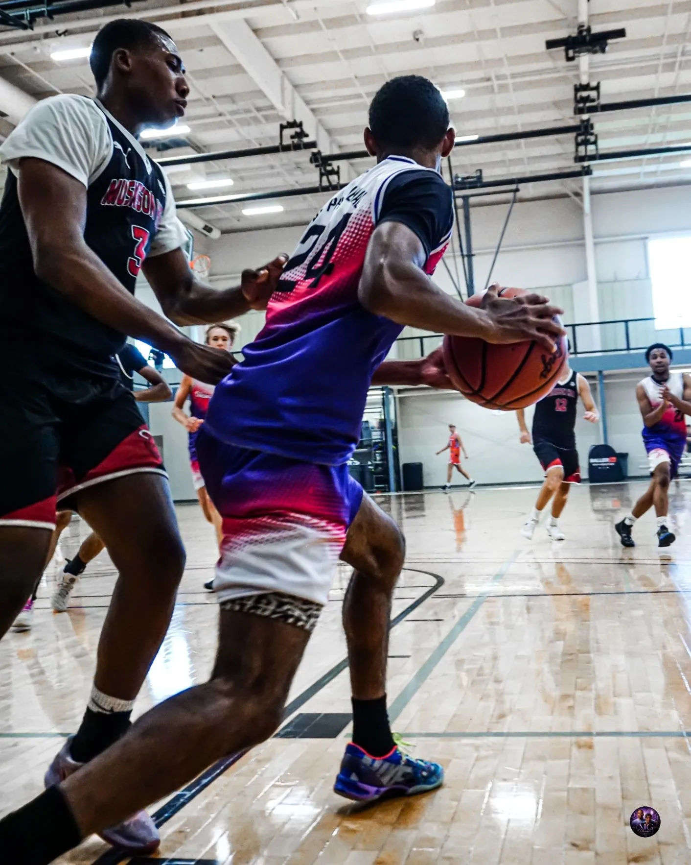Phenom Elite player drives toward the basket in his purple, pink, and white uniform